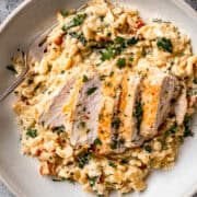 Tuscan chicken orzo in a white bowl on a blue table.