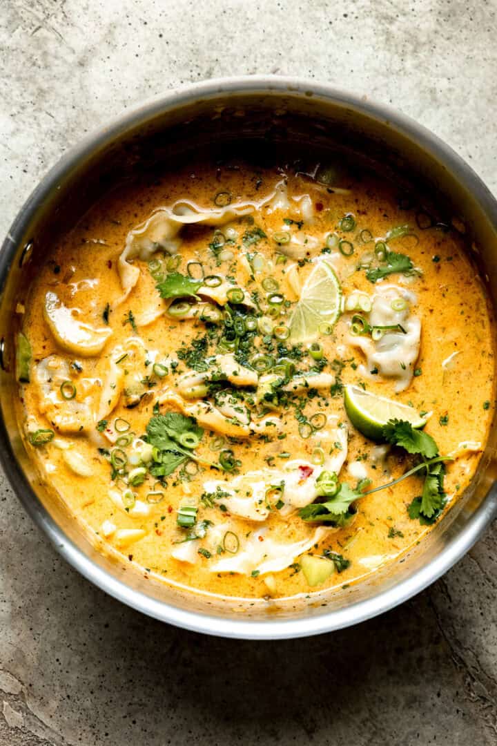Thai dumpling soup in a pot with limes.