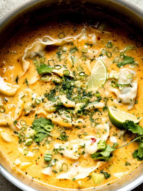 Thai dumpling soup in a pot with limes.