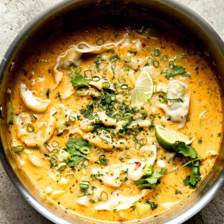 Thai dumpling soup in a pot with limes.